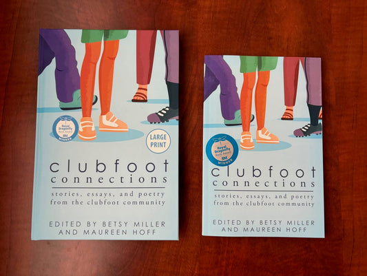 2 Clubfoot Connection books are on a table. The large-print hardcover book is next to the paperback. 
